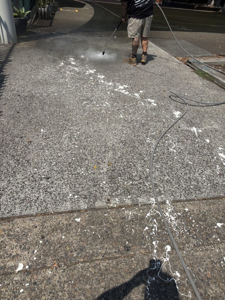 Pressure washing school pathway to remove graffiti